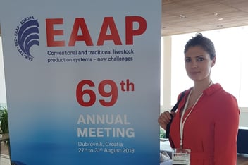 Eine Frau in einem roten Kleid steht vor einem Rollup der European Federation of Animal Science